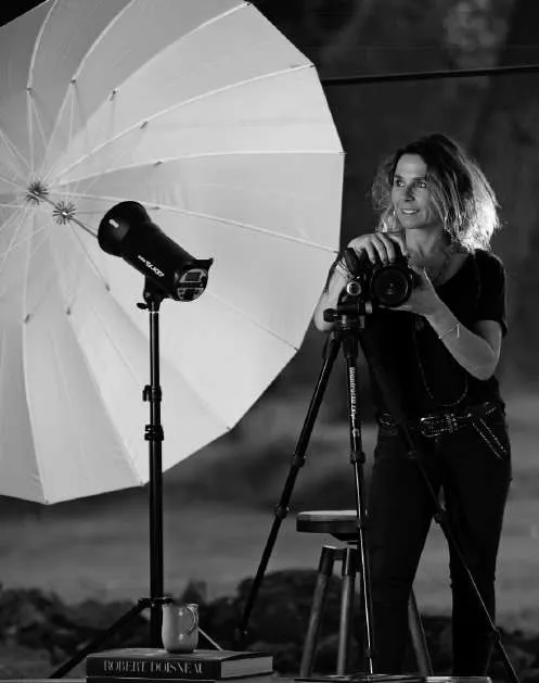Gloria Franke junto a su cámara en un trípode y un paraguas de iluminación de estudio